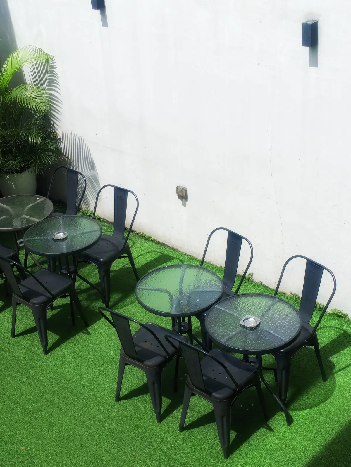Cafe tables and chairs on an artificial turf patio